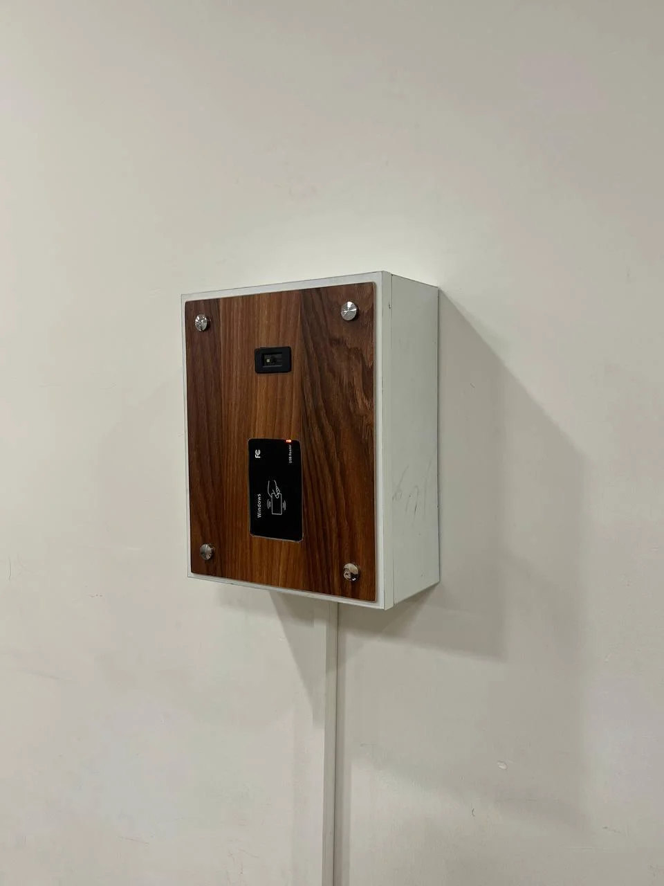 The Class Negar classroom terminal mounted on a wall: a wood-fronted enclosure housing an RFID reader and camera